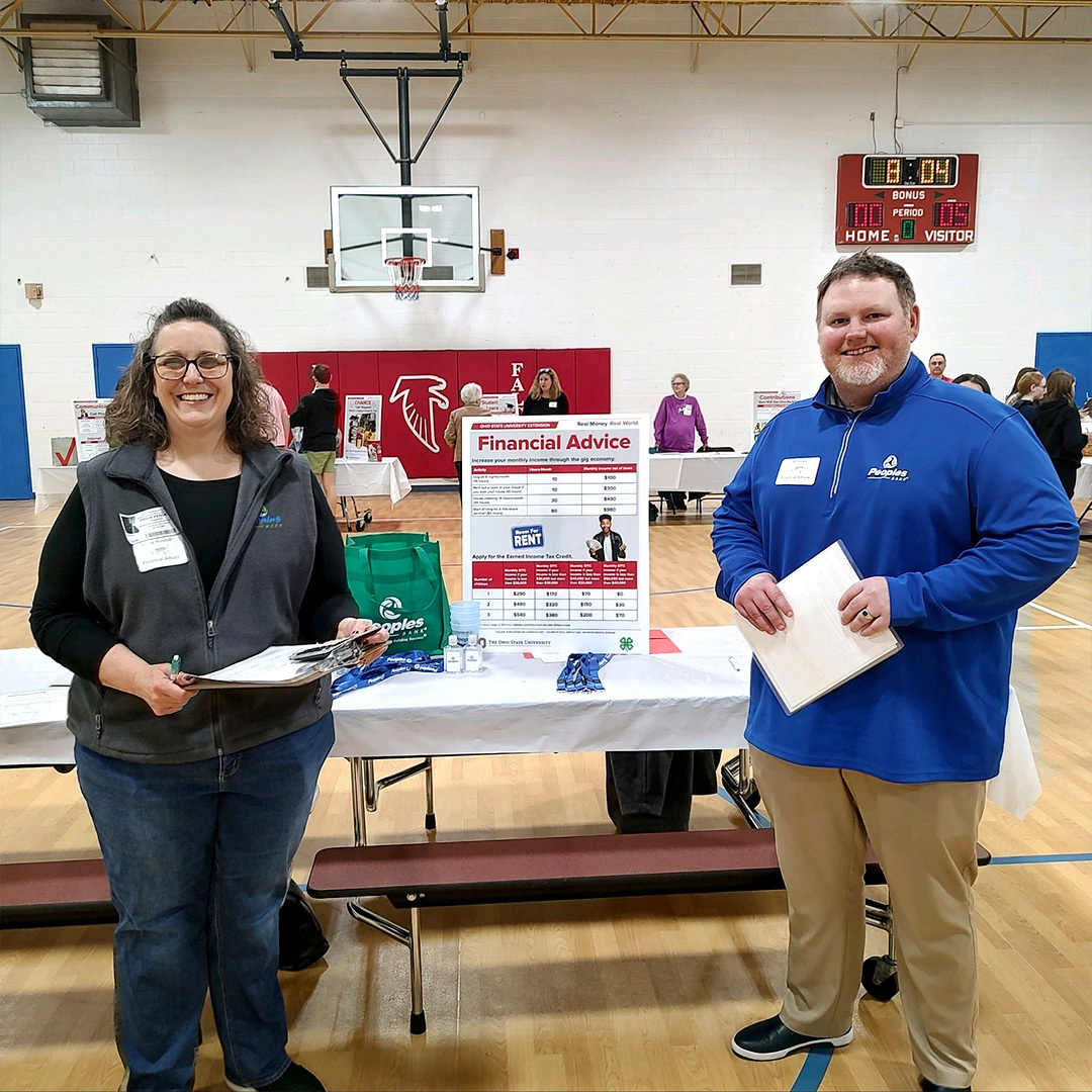 Fiona Pendell and JR Jones stand with their Financial Advice booth at the Real Money, Real World Financial Literacy event